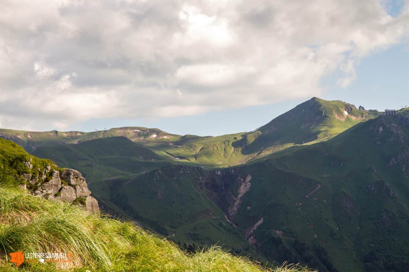 Sur les flancs du roc de Cuzeau, on aperçoit le cirque des Monts-Dore et le Sancy